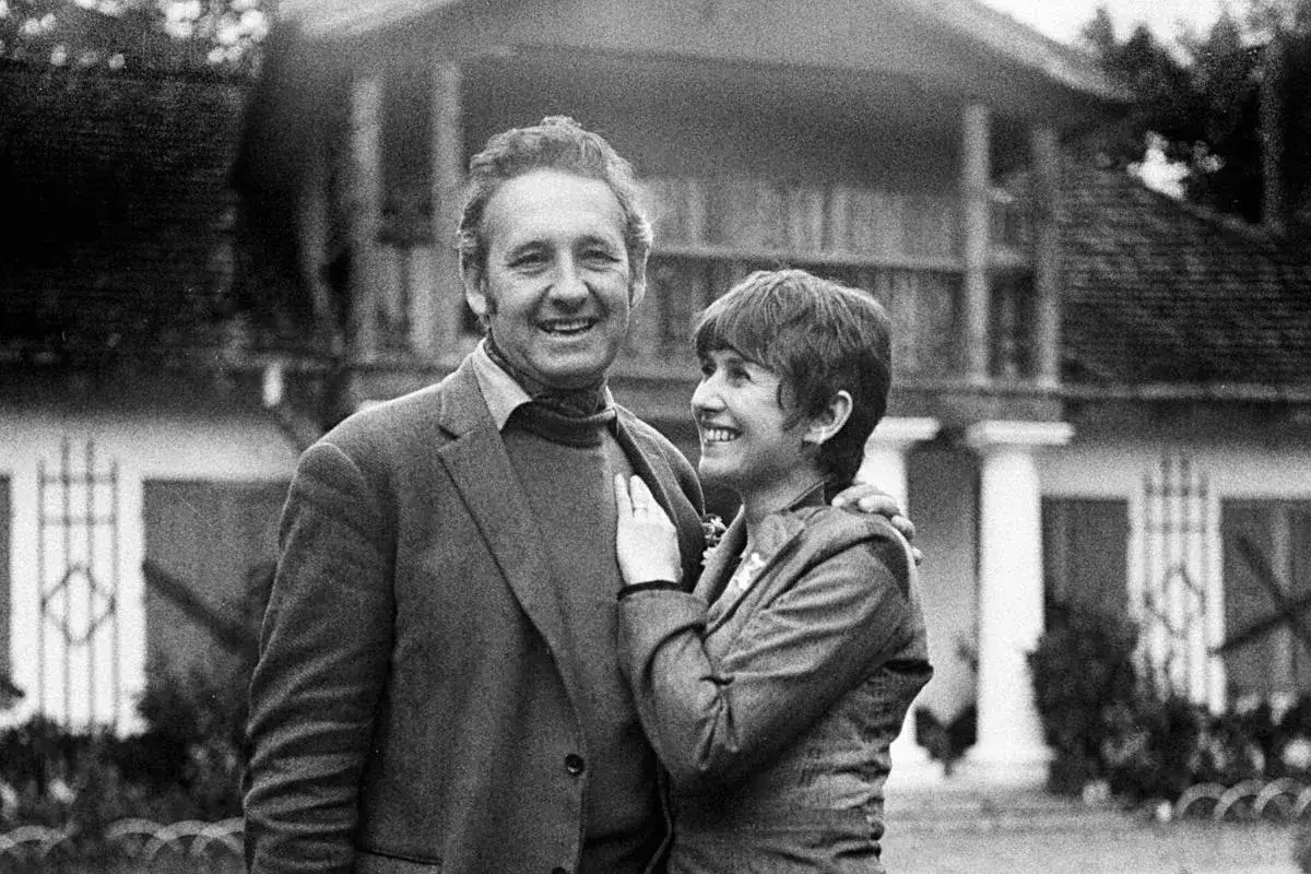 Andrzej Wajda i jego żona, Beata Tyszkiewicz, uśmiechają się do siebie na tle domu.
