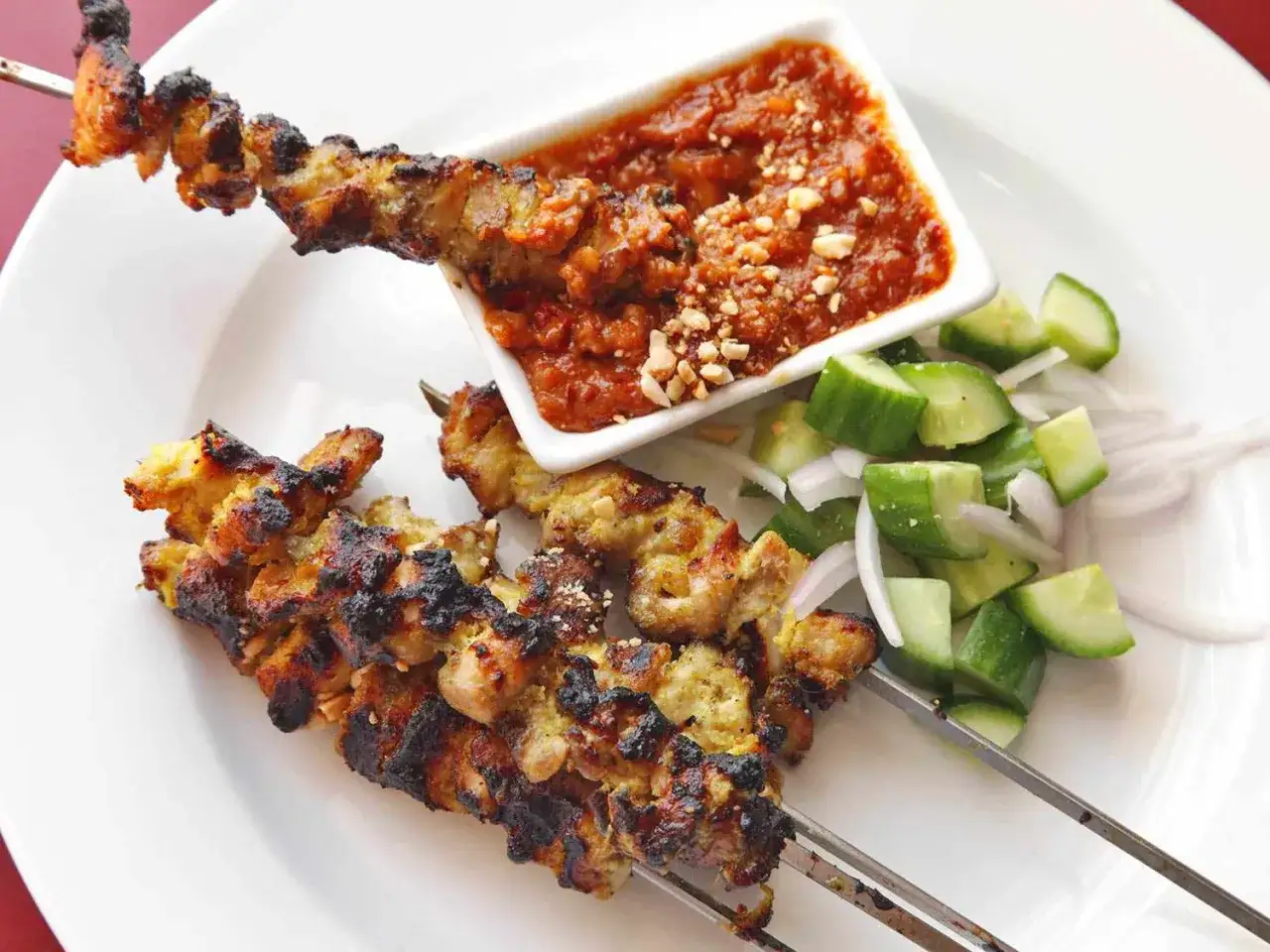 Grillad kyckling satay p&aring; spett med jordn&ouml;tss&aring;s och en fr&auml;sch gurksallad. En uts&ouml;kt asiatisk r&auml;tt.