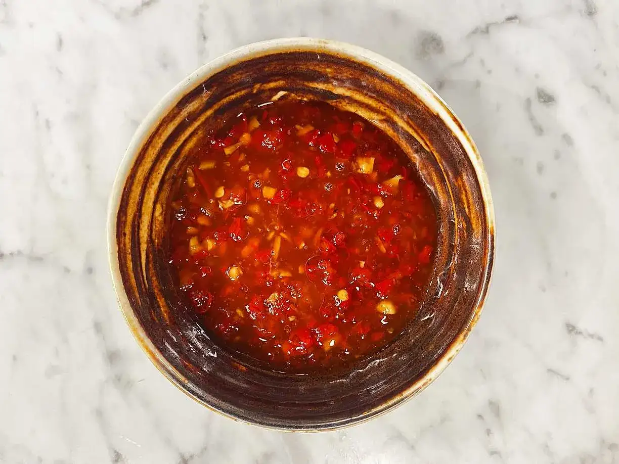 En sk&aring;l med h&auml;rlig, r&ouml;d sweet chili s&aring;s med sm&aring; bitar av chili och vitl&ouml;k. Perfekt till v&aring;rrullar eller kyckling.