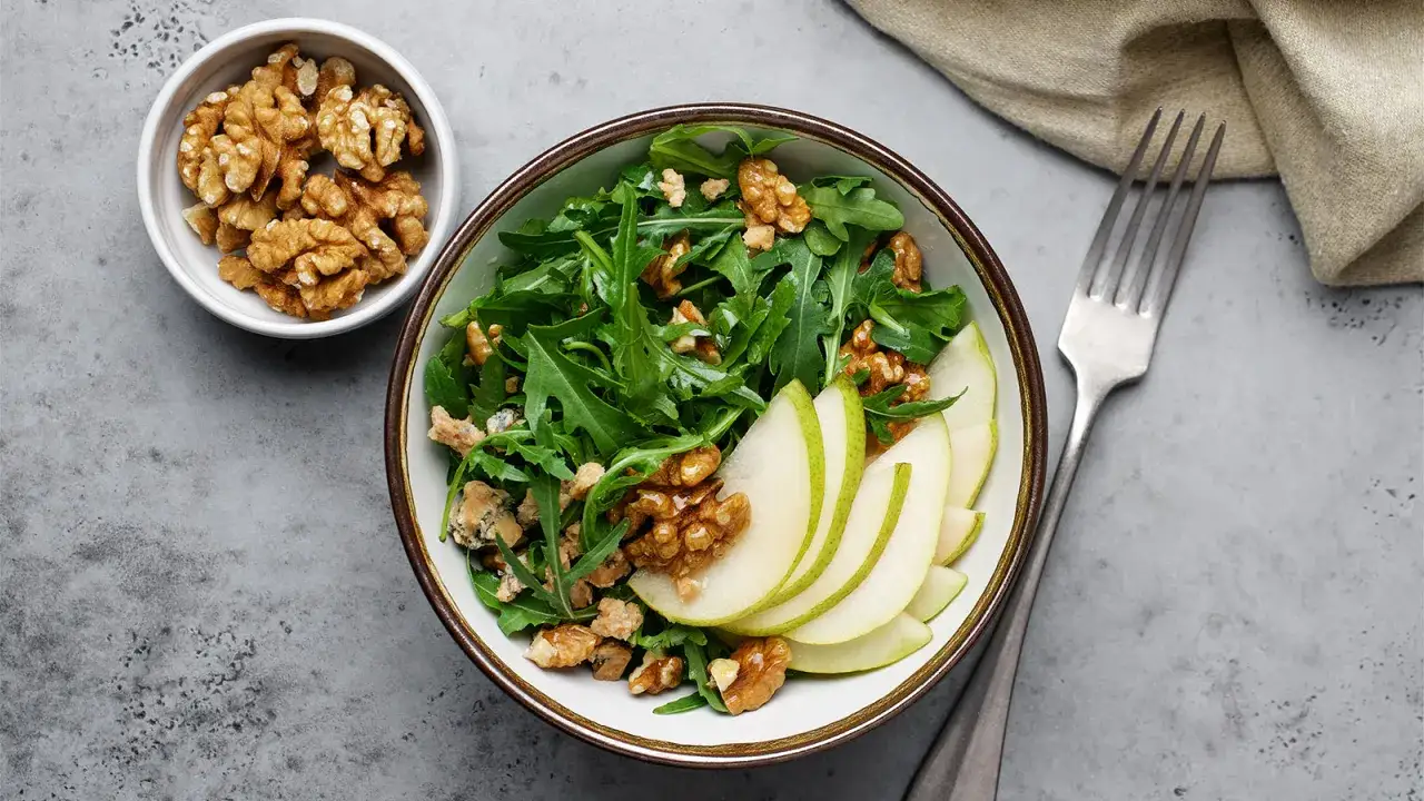 Salat mit Rucola, Birnenspalten und Walnüssen. Perfekt für leckere Walnuss Rezepte.
