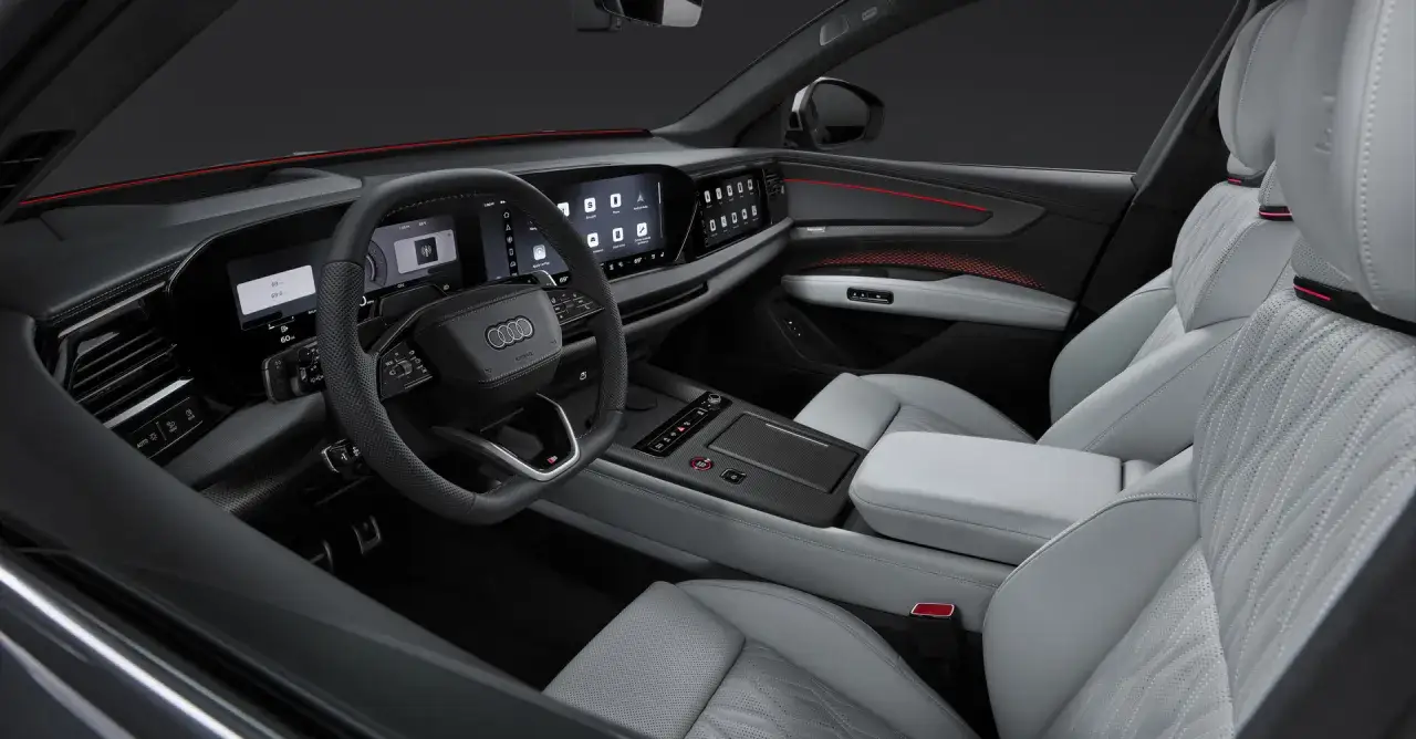 Wnętrze Audi Q9 z nowoczesnymi ekranami i jasną tapicerką. Zastanawiasz się nad audi q9 cena?