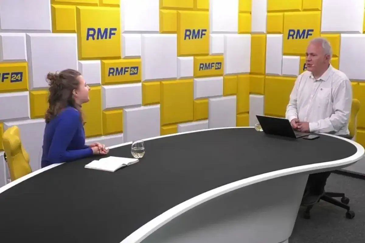 Rozmowa w studiu RMF FM. Kobieta w niebieskiej bluzce i mężczyzna w białej koszuli siedzą przy czarnym stole.