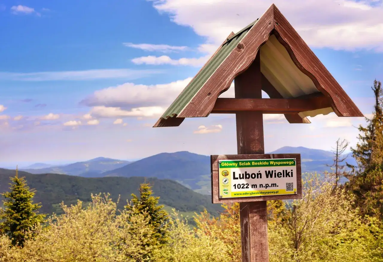 Tablica informacyjna na szczycie Luboń Wielki (1022 m n.p.m.) w Beskidzie Wyspowym. Piękny widok na góry i chmury. Idealne miejsce na piesze **beskid wyspowy trasy**.