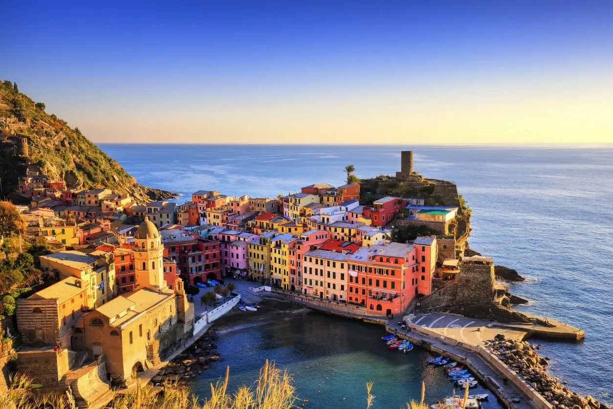 Colorate case aggrappate alla scogliera, una citt&agrave; sul mare nord Italia baciata dal sole.
