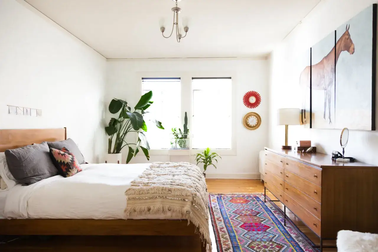 Colorful, patterned rugs for bedroom ideas, like this vibrant runner, add warmth and style to a cozy space with a wooden bed and dresser.