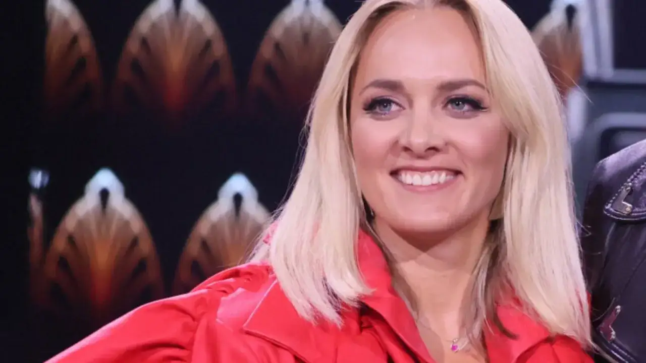 Uśmiechnięta blondynka w czerwonej marynarce, jak w