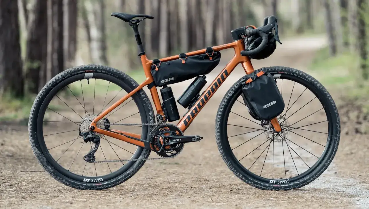 Orange gravel bikepacking Rad mit Ortlieb-Taschen, bereit für jedes Abenteuer.