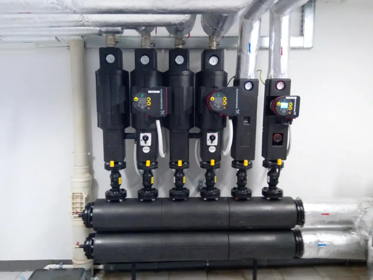Nowoczesne pompy obiegowe w hurtowni hydraulik Chojnice. Instalacja grzewcza z manometrami i izolowanymi rurami.