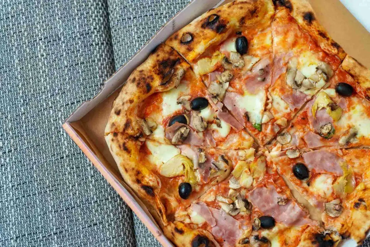 Pizza capricciosa składniki: szynka, pieczarki, karczochy, czarne oliwki i ser na chrupiącym cieście.