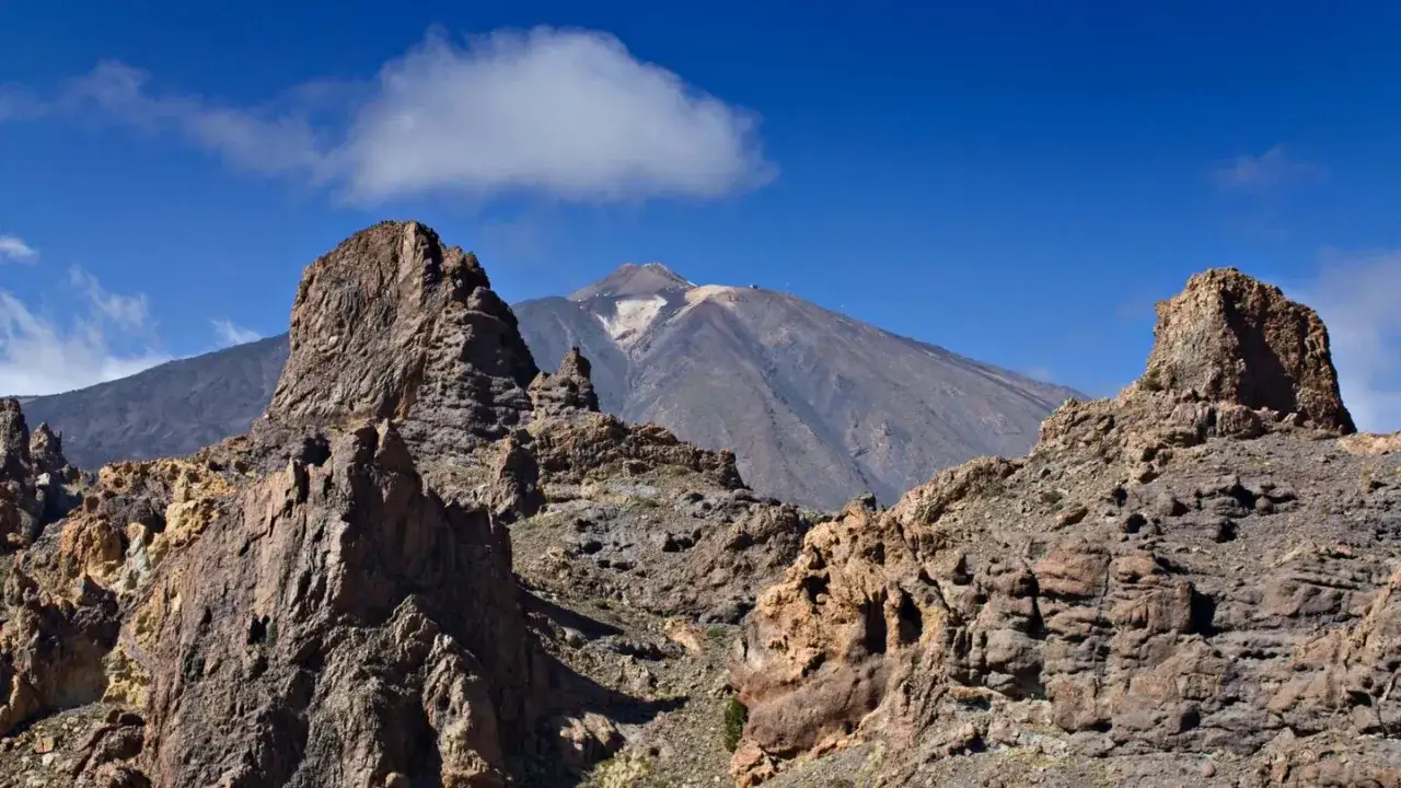Felsformationen im Vordergrund, im Hintergrund der majest&auml;tische Vulkan Pico del Teide im Teide Nationalpark.