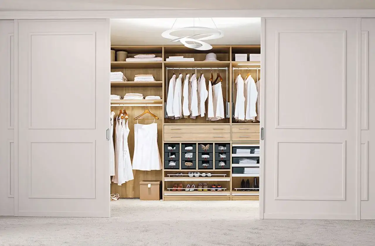 Ein offener Schrank verkleiden: Ein begehbarer Kleiderschrank mit Kleiderstangen, Schubladen und Schuhregalen, elegant und aufgeräumt.