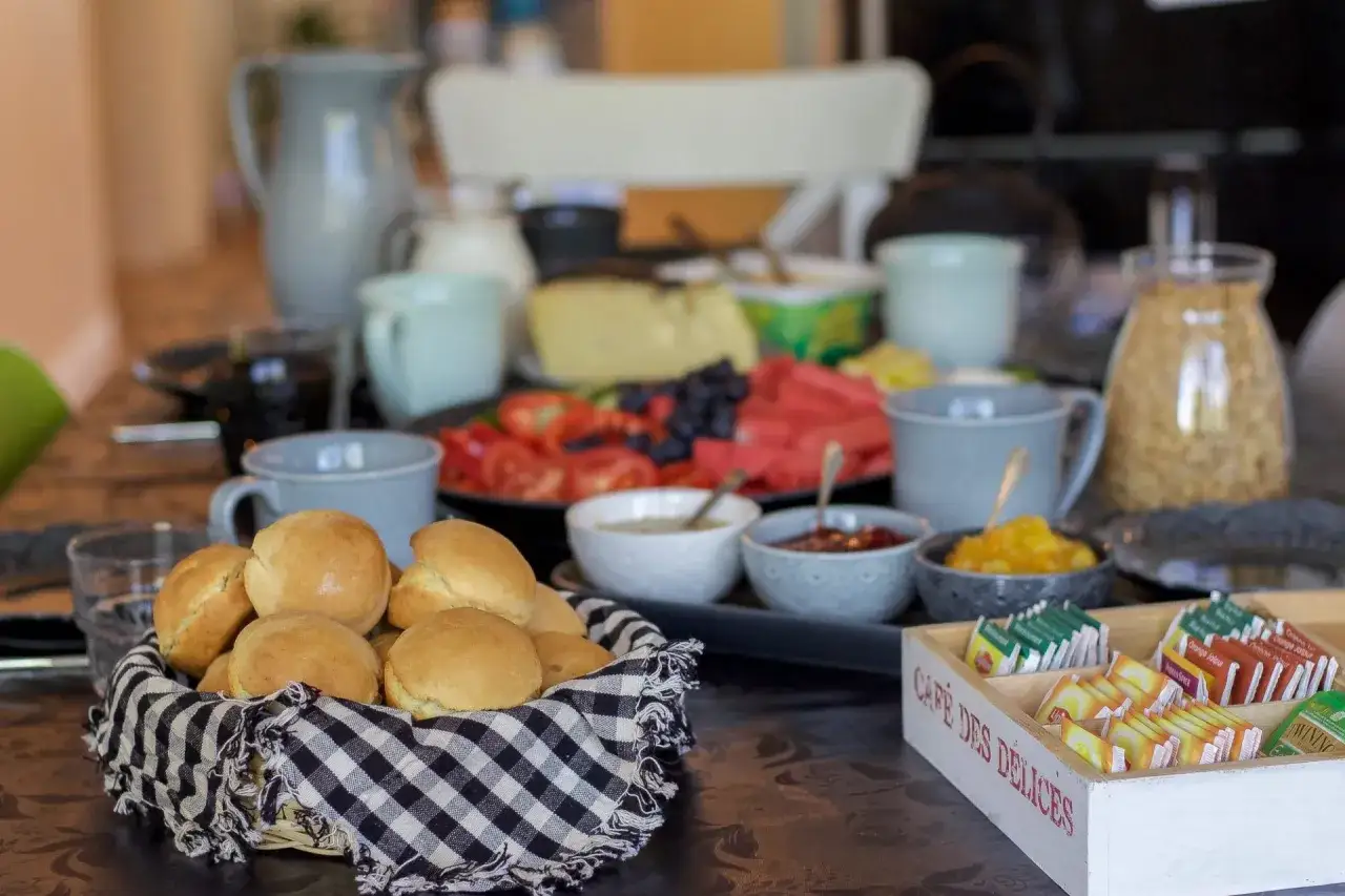 Frukostbuffé med korg full av nybakade scones över natten, frukt, ost och te.