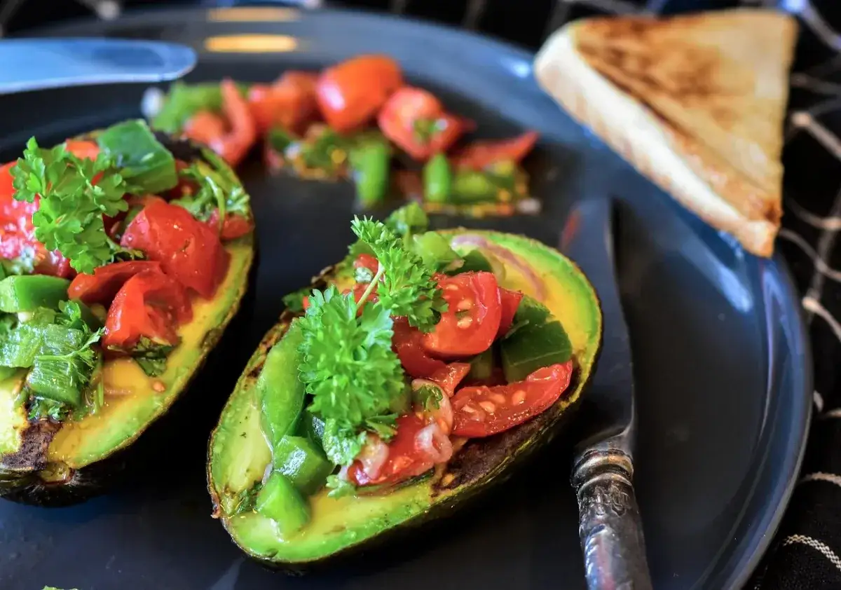 Połówki grillowanego awokado z salsą pomidorowo-paprykową, idealne jako zdrowe danie. Z czym jeść guacamole? Z takim awokado!