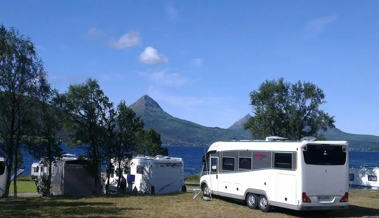 Husbil till Lofoten. Campingplats vid en sjö med berg i bakgrunden.