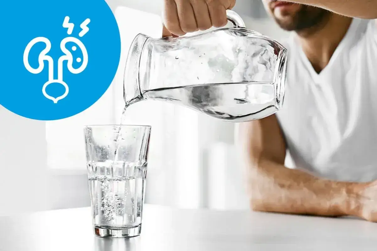 Picie wody jest kluczowe przy kamicy nerkowej. Na grafice widać, jak nalewana jest woda do szklanki, a obok symbol nerek.
