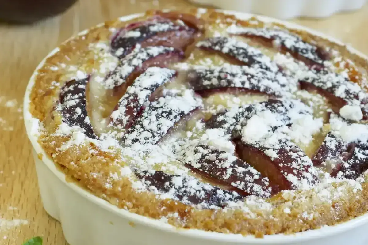 Tarte aux prunes sur pâte briochée, saupoudrée de sucre glace. Une délicieuse recette pour un dessert gourmand.