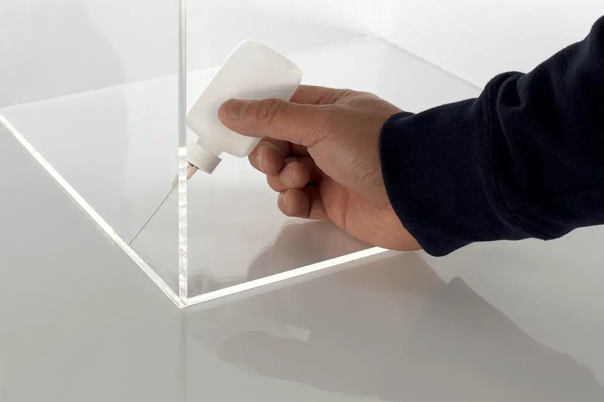 Applying a thin bead of solvent to join acrylic sheets. This method ensures does resin stick to acrylic effectively for a strong bond.