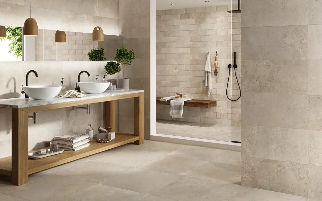 Salle de bain moderne avec double vasque. Le carrelage sol au mur crée une ambiance chaleureuse et uniforme.