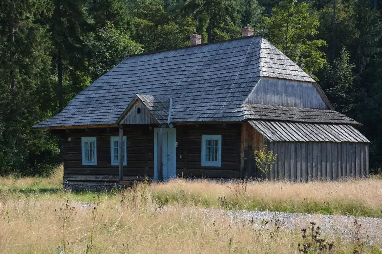 Drewniana chata w Zubrzycy Górnej, jedna z atrakcji regionu, otoczona dziką przyrodą.