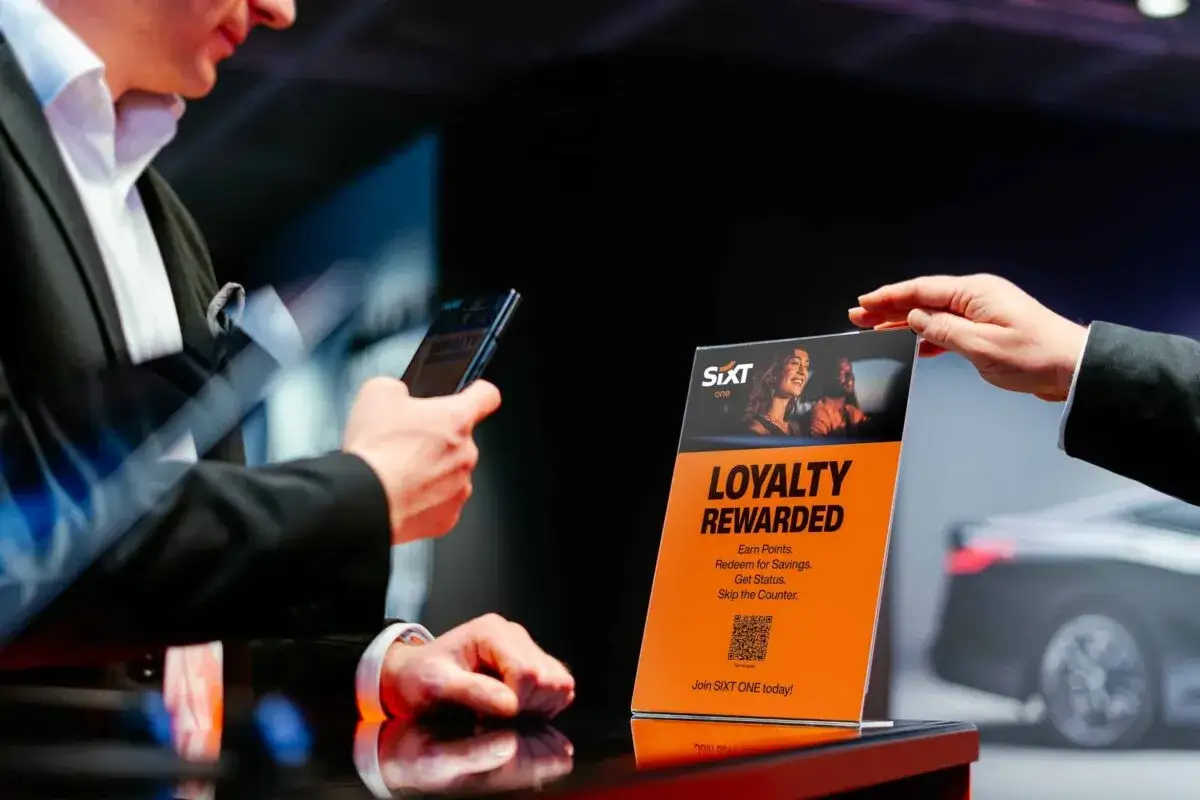 Mann scannt mit Handy QR-Code auf SIXT ONE 