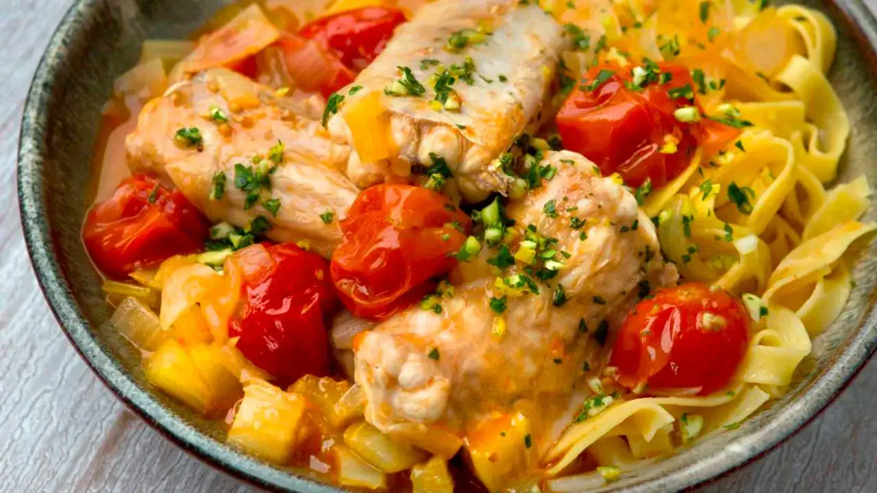 Délicieuse cuisson saumonette avec tomates cerises, oignons et pâtes fraîches, le tout parsemé de persil frais.