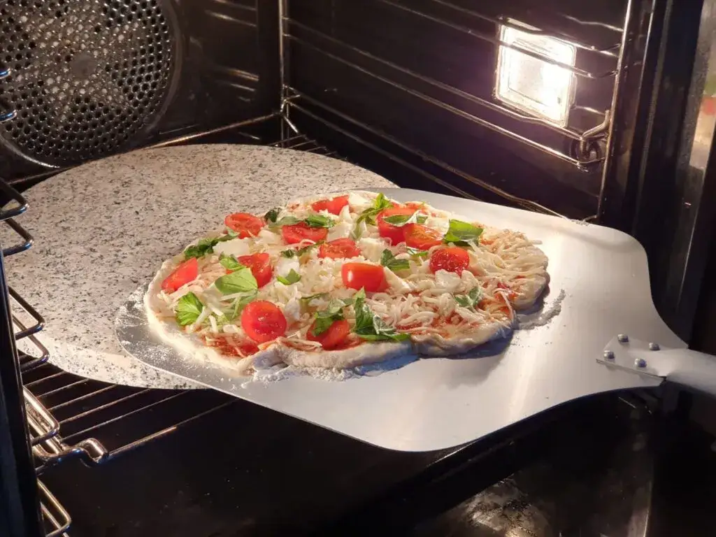 Pieczenie pizzy w domowym piekarniku na kamieniu do pizzy