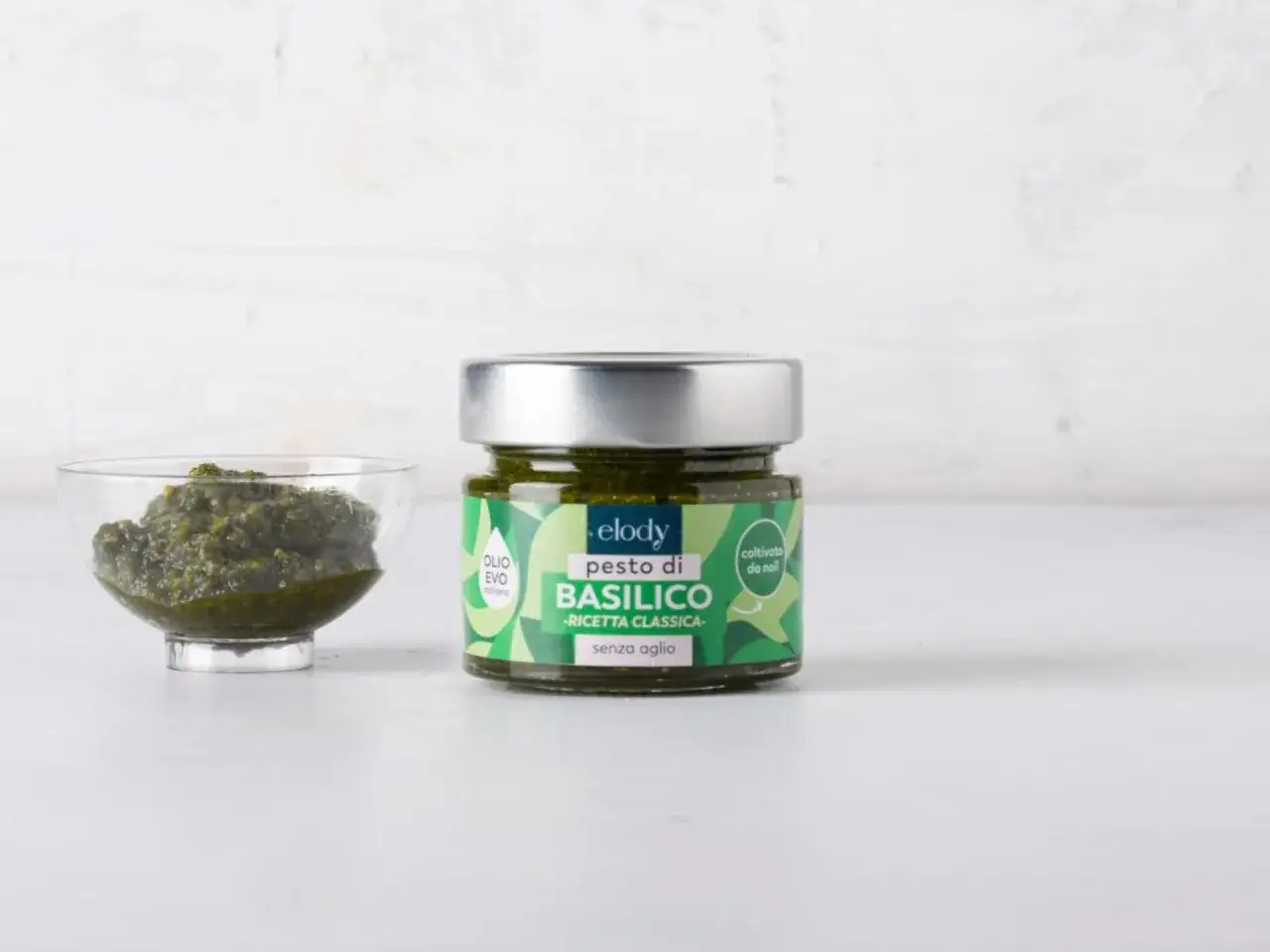 Un vasetto di pesto di basilico senza aglio, con una ciotolina di pesto accanto. La ricetta classica elody &egrave; coltivata da noi.
