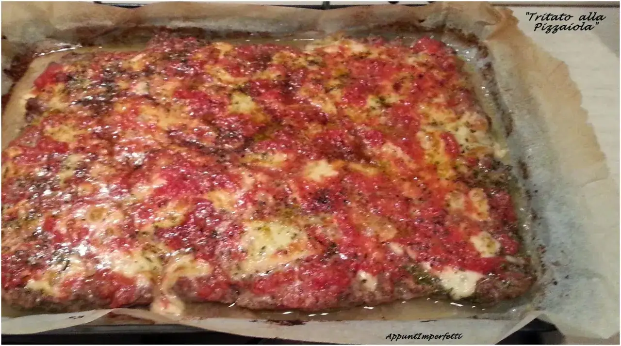 Tritato alla pizzaiola con patate, cotto al forno su carta da forno, con pomodoro filante e spezie.