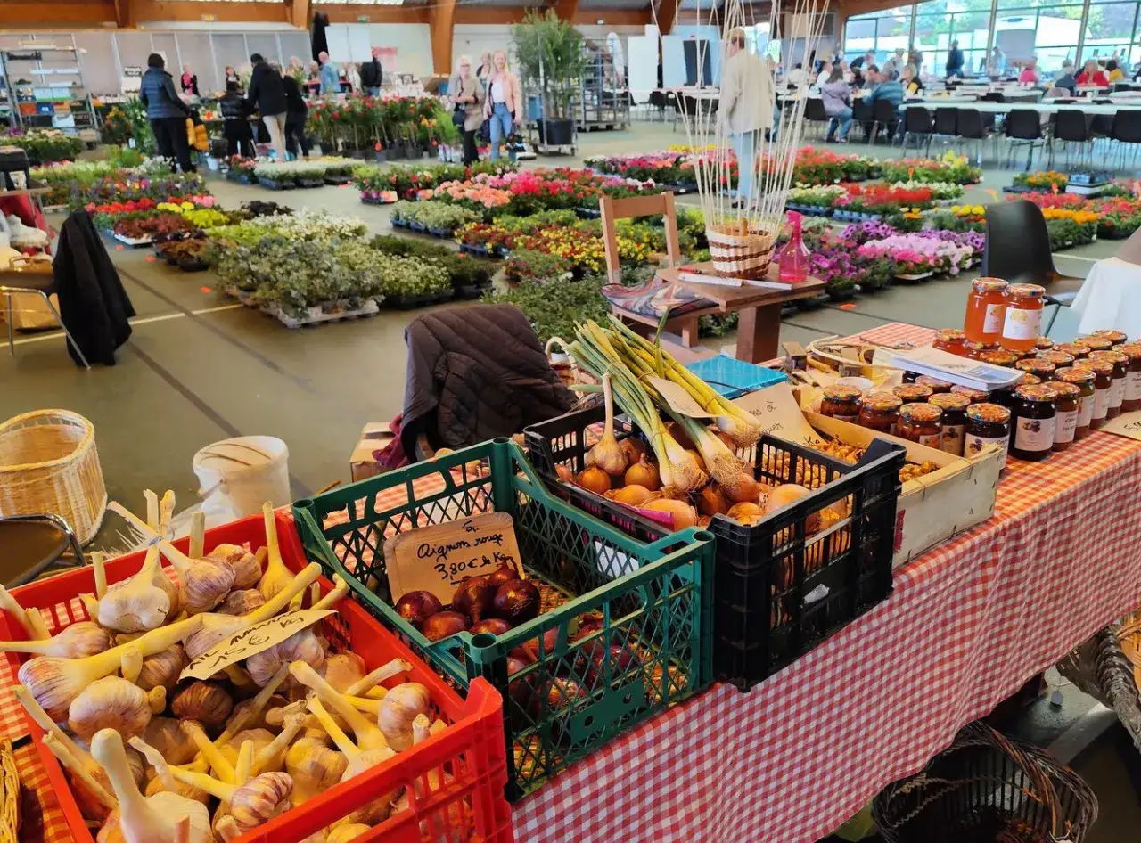 Ambiance de marché : oignons, ail, confitures et fleurs pour un **terroir en fête**.