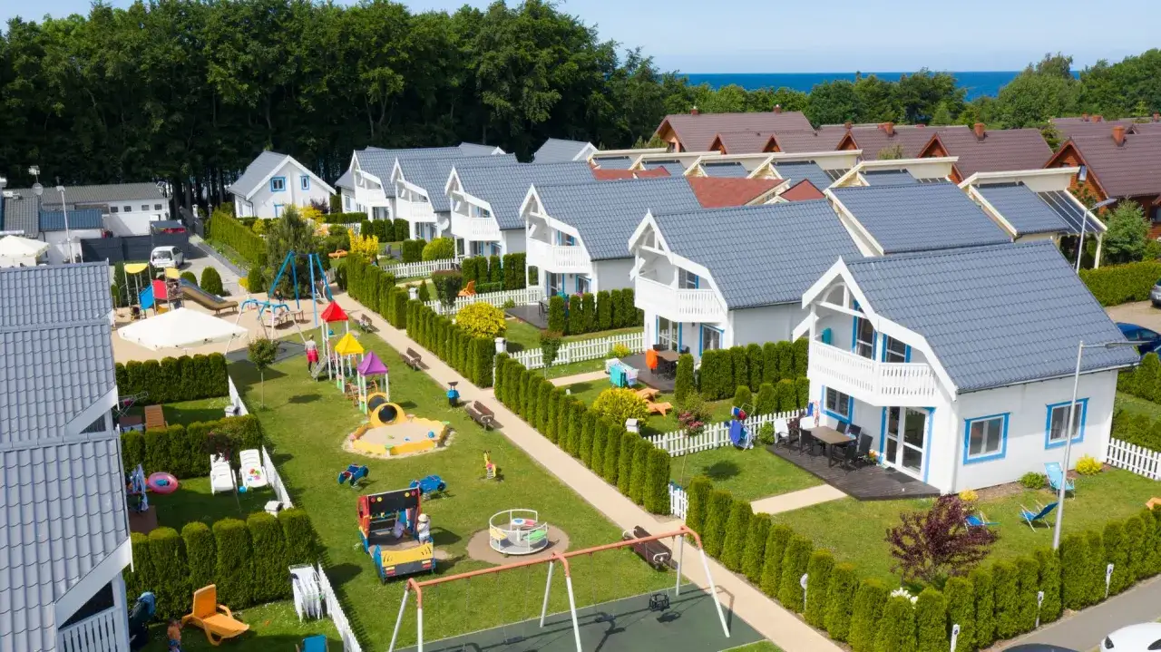 Właściciel Collins Resort dba o rodzinne wakacje. Widać domki, plac zabaw i zieleń.