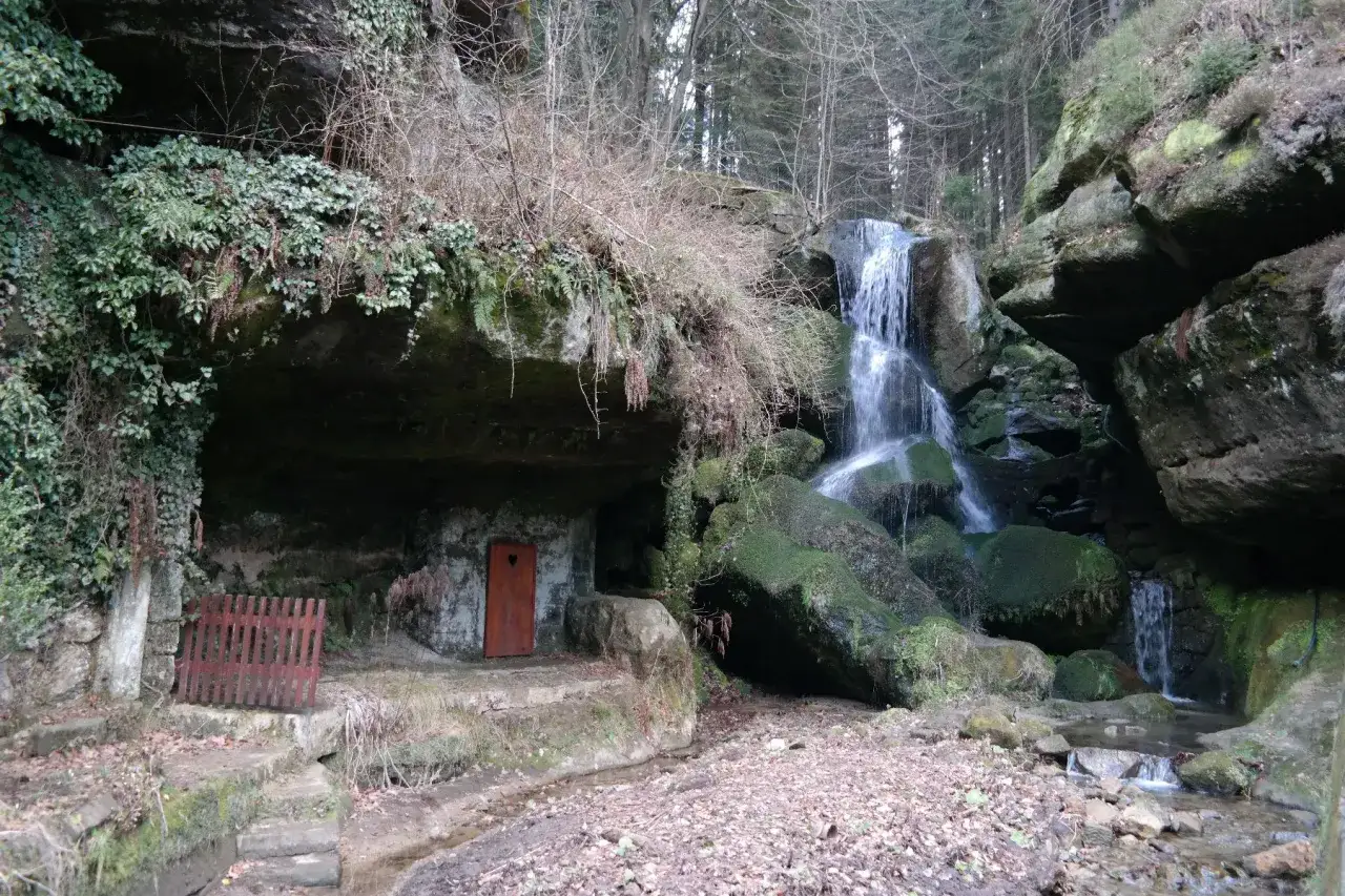 Ein versteckter Wasserfall bei Bad Schandau, mit einer kleinen H&ouml;hle und einer T&uuml;r mit Herz.