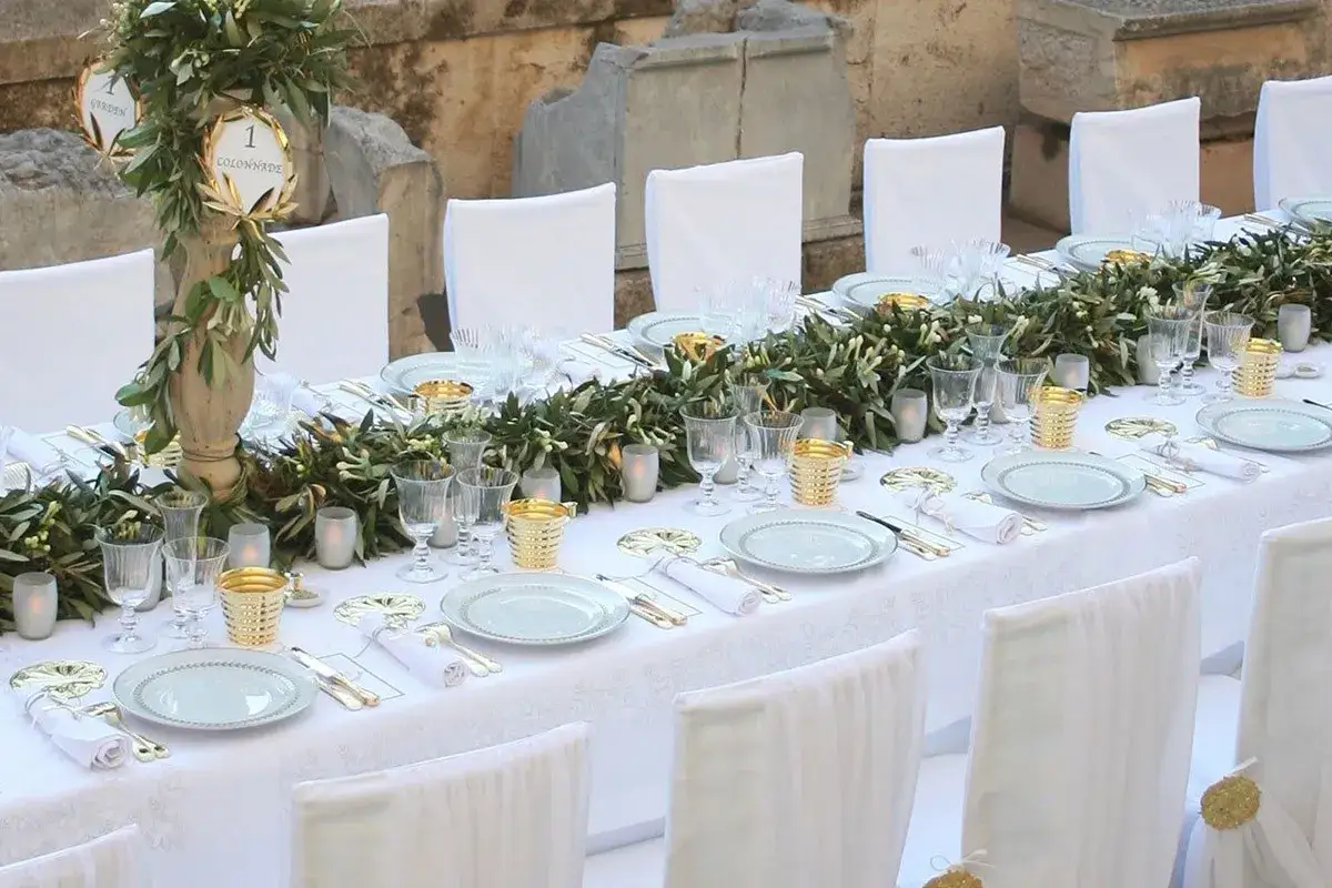 Table dress&eacute;e pour une f&ecirc;te, avec des guirlandes d'olivier et des bougies. Un texte de remerciement noces d'or pourrait accompagner cette belle table.