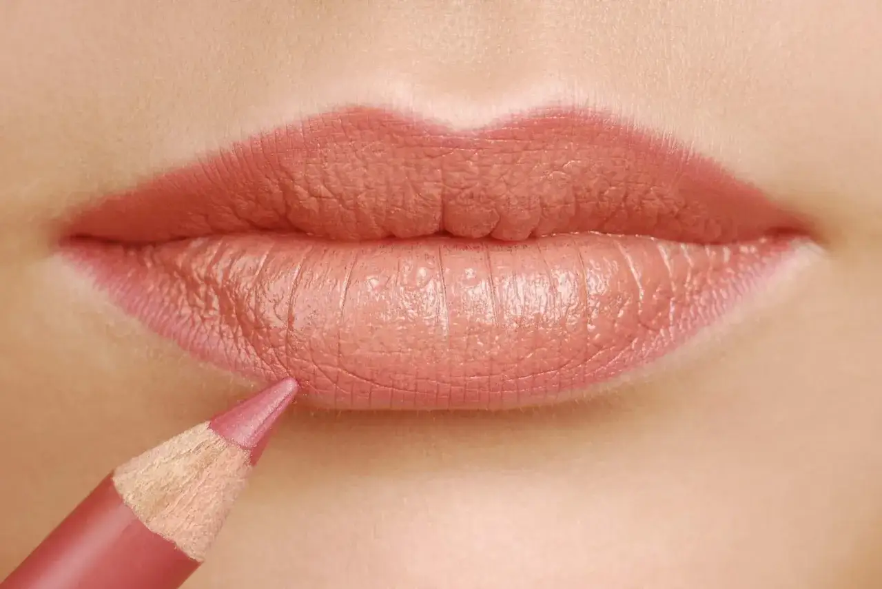 Dettaglio di labbra con matita rosa che definisce il contorno, mostrando come si mette la matita labbra per un look perfetto.