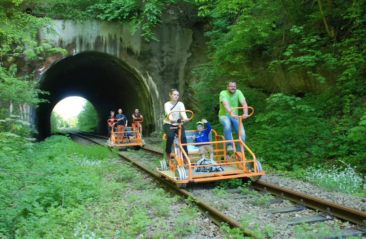 Rodzina odkrywa nowe trasy rowerowe Podkarpacie, pedałując przez zielony tunel.
