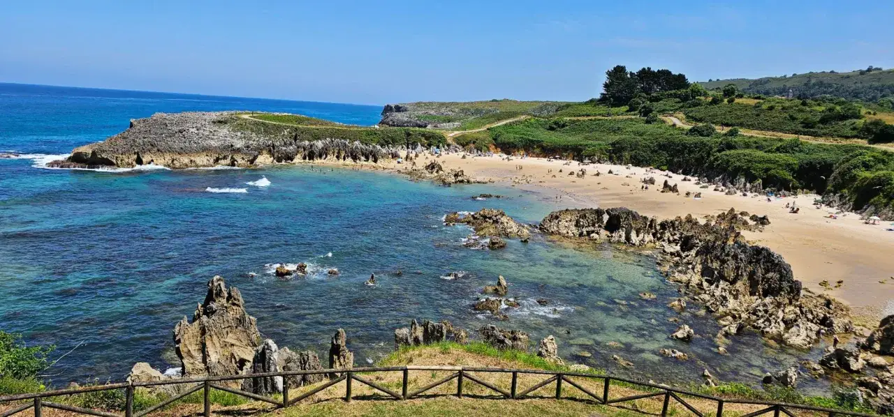 Playa de Gulpiyuri, un tesoro natural que ver en Nueva de Llanes. Aguas cristalinas, arena dorada y formaciones rocosas únicas.