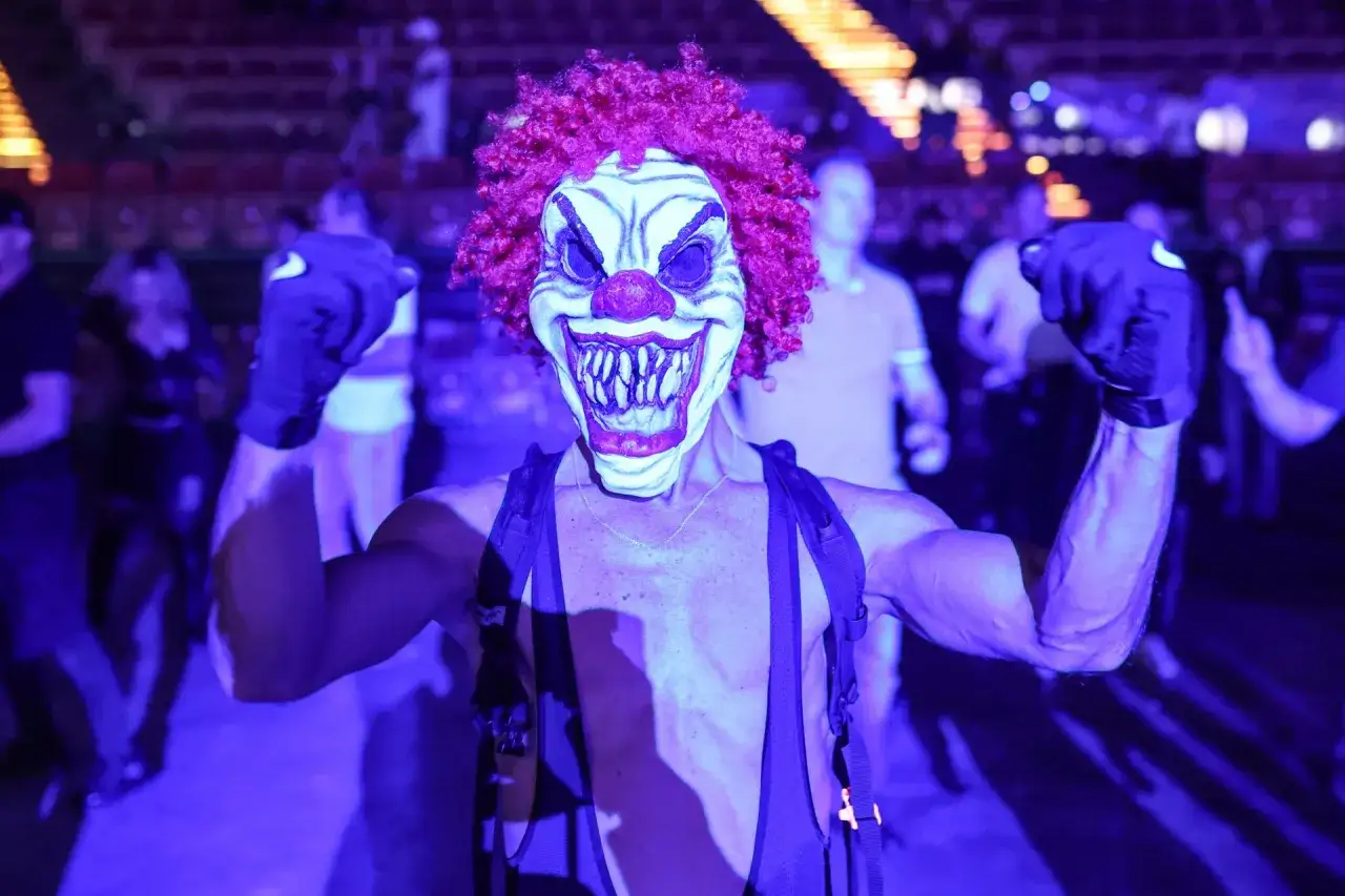Przerażający klaun w czerwonej peruce i masce z zębami, w mrocznym klubie. Może to być sygnał 
