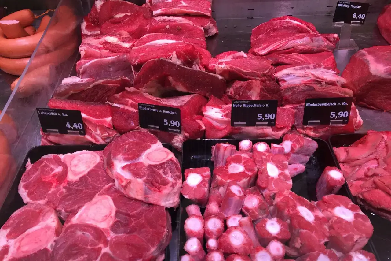 Gros morceaux de type de viande rouge, dont des os à moelle et des côtes, sont présentés dans une boucherie.