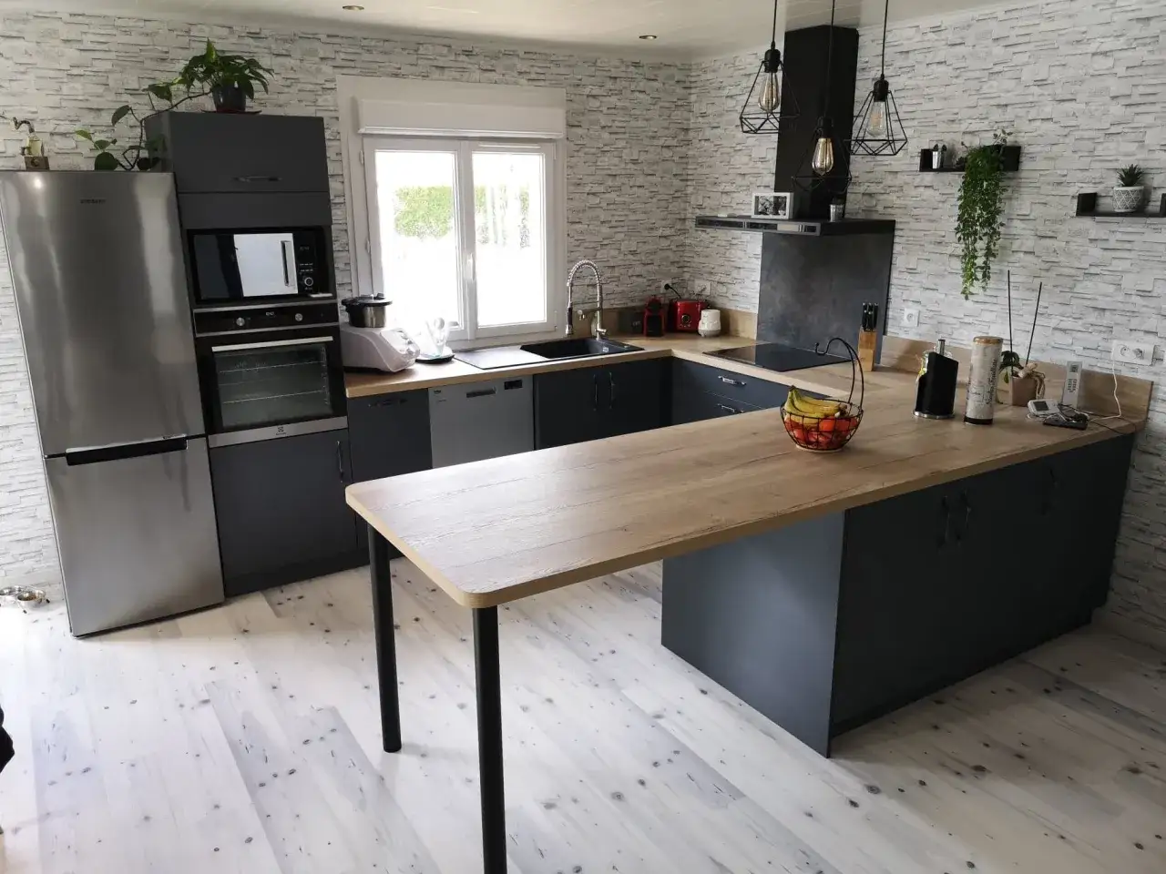 Cuisine en U moderne de 5m2, optimisée pour une petite surface. Plan de travail en bois clair, meubles gris anthracite, électroménagers intégrés.