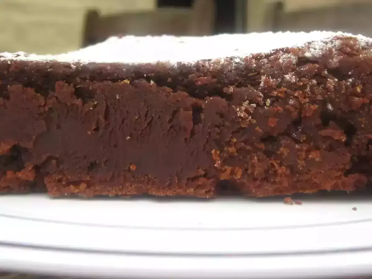 Tranche de g&acirc;teau au chocolat, entre moelleux et fondant, saupoudr&eacute;e de sucre glace.