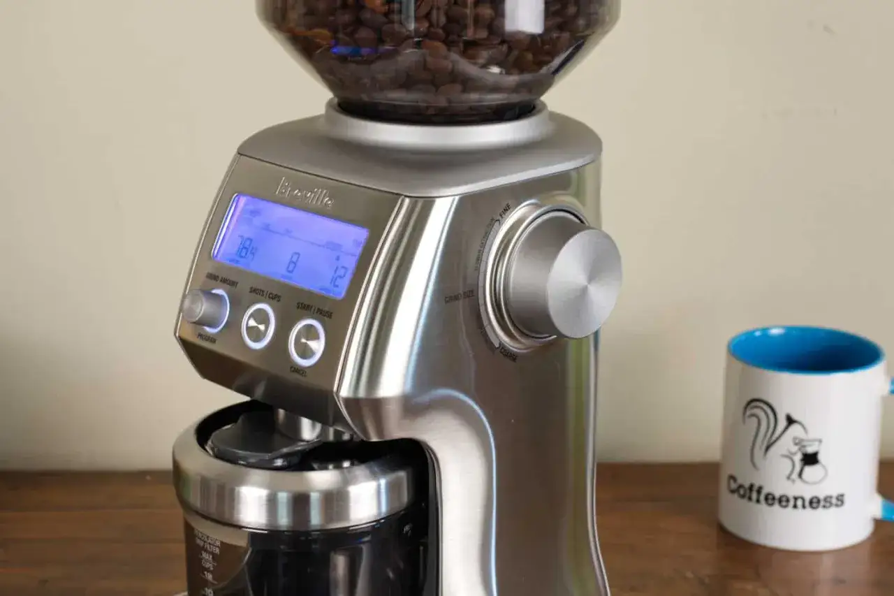 Sage Smart Grinder Pro: Mahlgrad für Espresso einstellen. Die Anzeige zeigt 78.4, 8 und 12. Daneben eine Kaffeetasse mit Eichhörnchen.