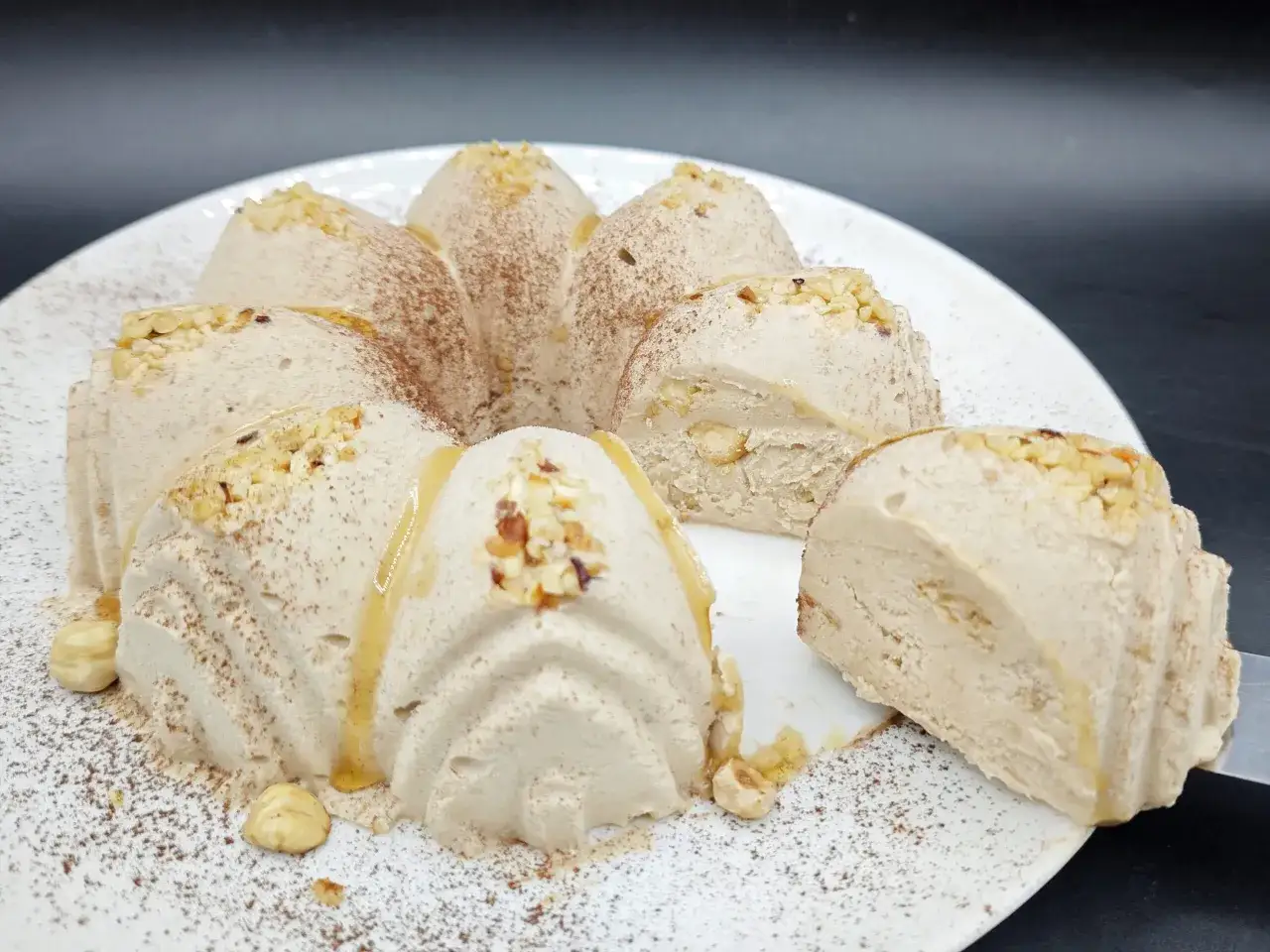 Delicioso coulant de avellana con trozos de frutos secos y un toque de miel, espolvoreado con cacao.
