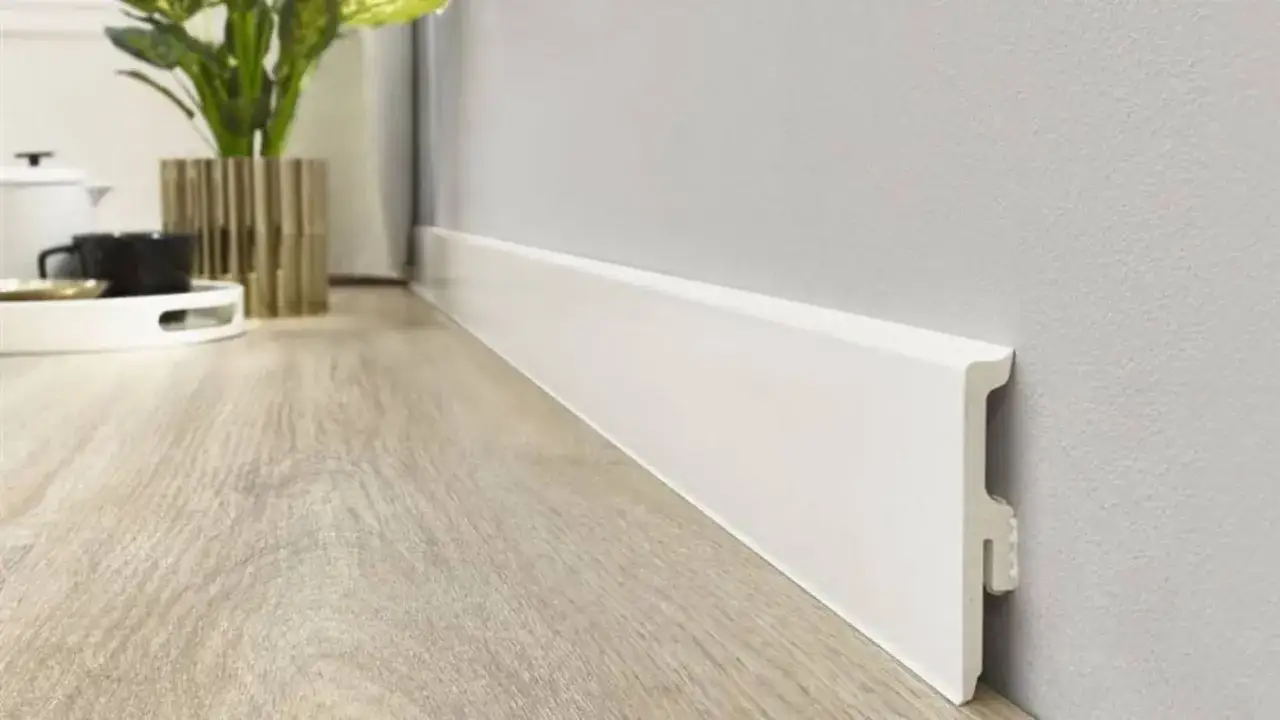 Rodapi&eacute; blanco minimalista, parte de las tendencias rodapi&eacute;s modernos, complementa un suelo de madera clara y decoraci&oacute;n elegante.