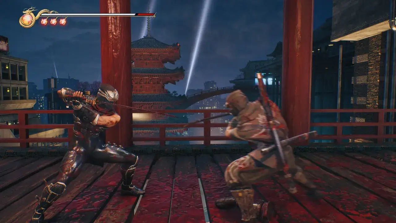 Dwóch ninja walczy na krwawej drewnianej platformie. W tle widać japońską pagodę i nocne miasto. To scena z gry Ninja Gaiden Black na Xbox.