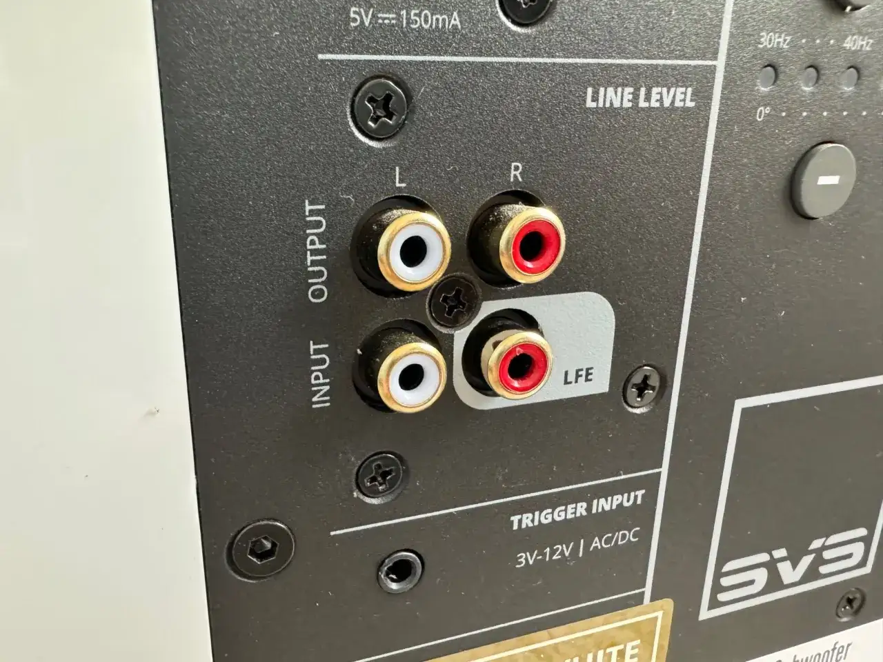 Nahaufnahme der Anschlüsse eines Subwoofers. Links sind