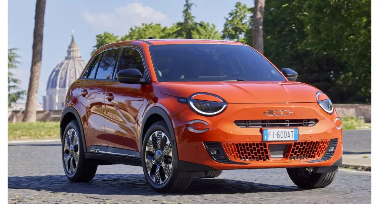 El nuevo Fiat 600, un SUV naranja vibrante, se luce en Roma con la c&uacute;pula de San Pedro de fondo.