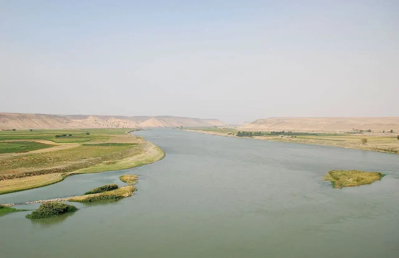 El río Éufrates serpentea entre tierras fértiles y desérticas, uniendo civilizaciones a través de su vasto cauce.
