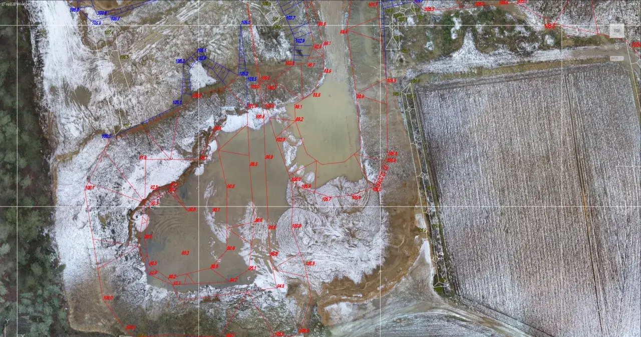 Geodeta wyznacza granice działek na terenie podmokłym, pokrytym śniegiem. Linie i punkty pomiarowe wskazują, co robi geodeta.