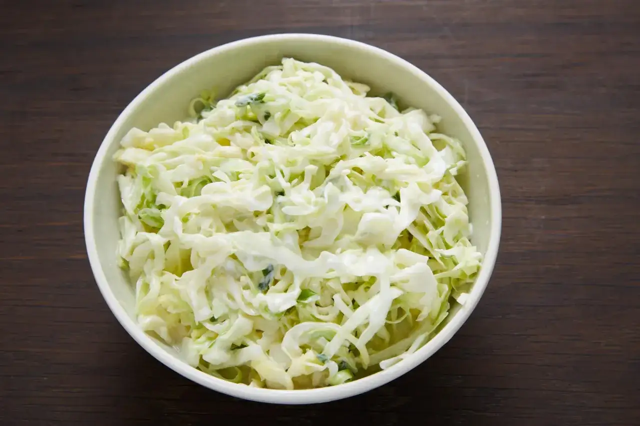 Schüssel mit cremigem Krautsalat, der mit einem köstlichen Coleslaw Dressing verfeinert ist.