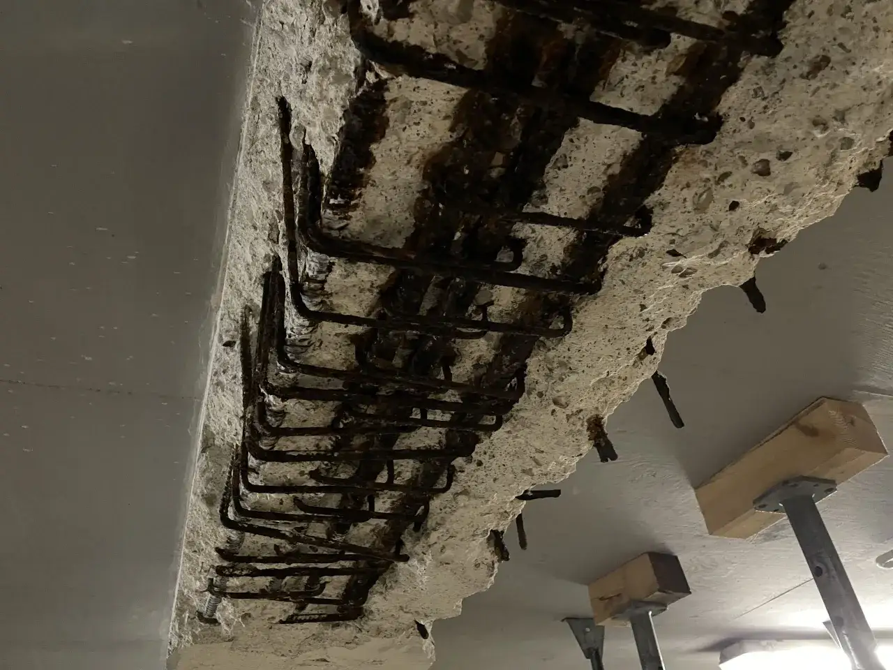 Widoczne zbrojenie z widoczną korozją, beton uległ degradacji, co świadczy o minimalnej otulinie zbrojenia.
