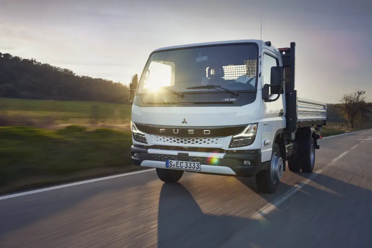 Camion blanc Fuso en mouvement, id&eacute;al pour la consommation camion 7 tonnes. Le soleil brille &agrave; travers le pare-brise.